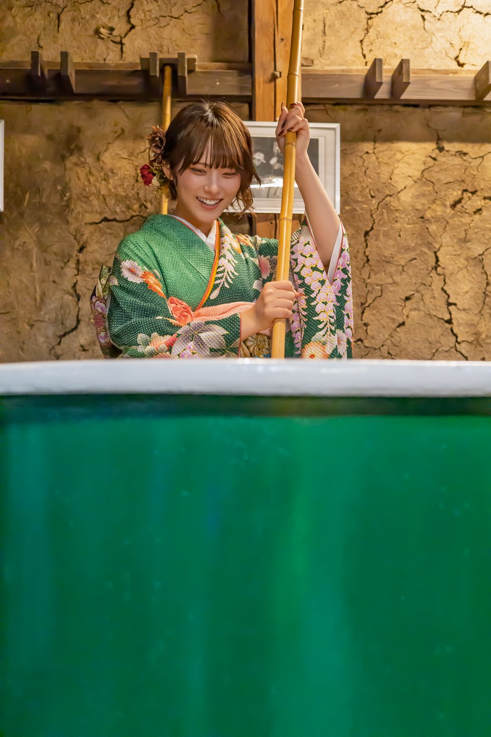 もろみの樽の前で笑顔のさがすずかさん