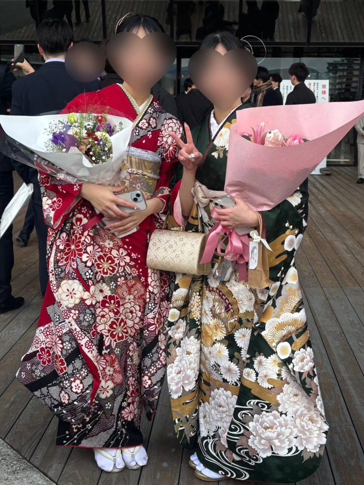 赤と深緑の振袖でお花を持つお客様おふたり（成人式会場）