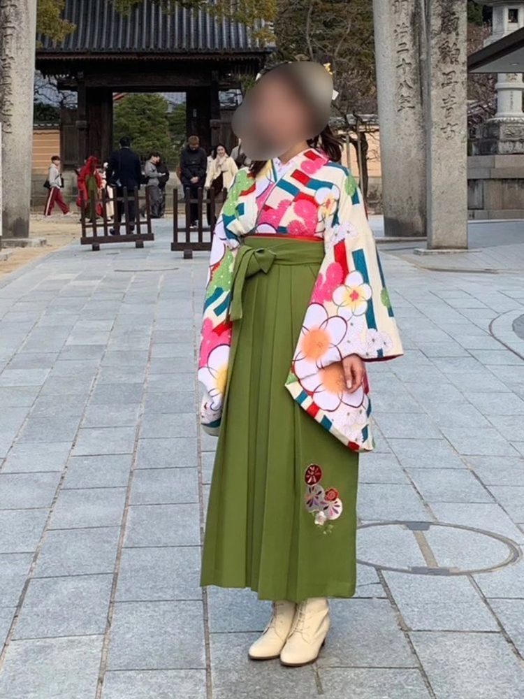白地に彩り花の二尺袖に抹茶色の袴・ブーツのお客様（卒業式）