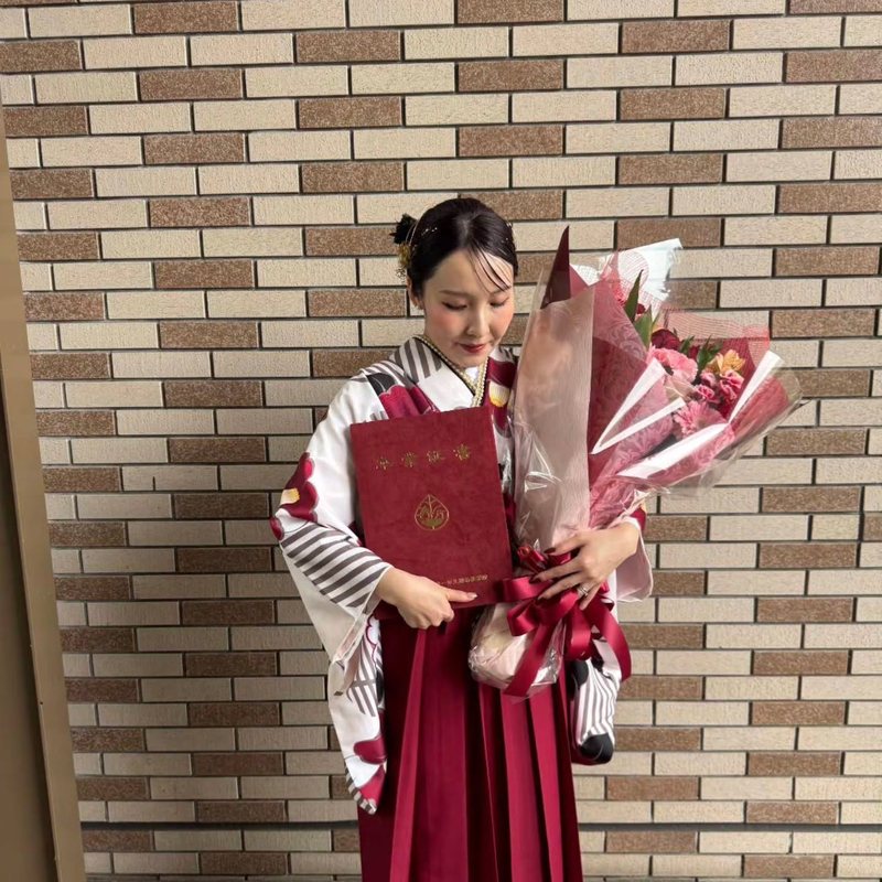 白地の二尺袖にえんじの袴・花束を持つお客様（卒業式）